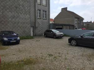 three cars parked in a parking lot next to a building at Appartement pour 4 personnes à Fort-Mahon Plage in Fort-Mahon-Plage