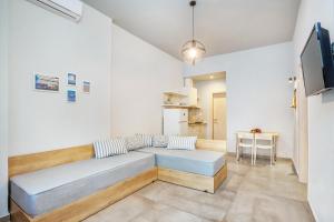 a living room with a couch and a tv at Armyra studios in Pefkochori