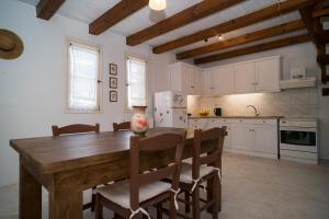 a large kitchen with a wooden table and chairs at Jasmine House in Tsilivi