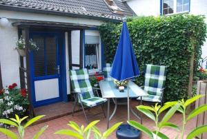 a patio with a table and a blue umbrella at Schlichte in Kirchdorf