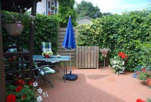 a patio with a blue umbrella and a table at Schlichte in Kirchdorf +7 photos