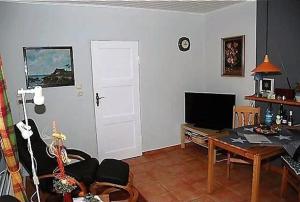 a living room with a table and a television at Schlichte in Kirchdorf