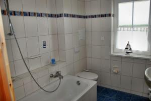 a bathroom with a tub and a toilet and a sink at "Tau Hus" im "Roden Hus" in Timmendorf +11 photos