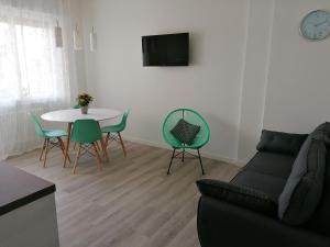 sala de estar con sofá, mesa y sillas en ANGELA GUEST HOUSE in centro storico en Conegliano