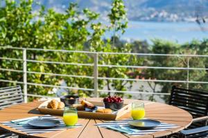 a wooden table with a tray of bread and orange juice at The H Experience - The Blue Lounge with Swimming pool in Porto Rafti