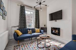 a living room with a blue couch and a tv at Central Belfast Apartments: Georgian House in Belfast