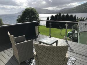 a deck with chairs and a view of the water at Campfield House in Fort William