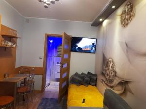 a living room with a yellow couch and a tv on the wall at Tu się śpi in Bodzentyn
