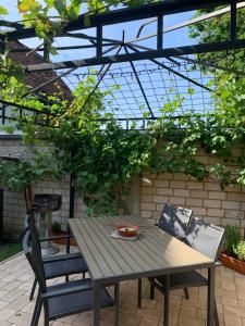 una mesa de madera y 2 sillas sentadas bajo una pérgola en Ferienwohnung Hoffmann, en Gangelt