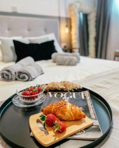 a tray with a pastry and strawberries on a bed at Milea Mansion in Limassol +19 photos