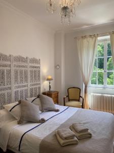 a bedroom with a large bed with two towels on it at La Maison des Fontaines d'Alsace in Ferrette