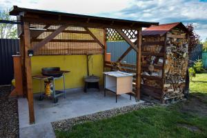 een houten paviljoen met een grill en een grill bij LUX Apartman Maroslele in Maroslele