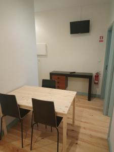 een tafel met stoelen en een bureau in een kamer bij Near River 63 in Vila Nova de Gaia