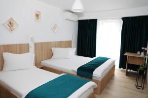 um quarto de hotel com duas camas e uma janela em Hotel Dunavis em Orşova
