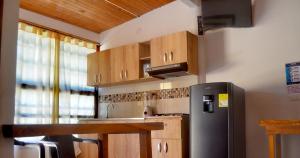 a kitchen with a stainless steel refrigerator and wooden cabinets at Hotel Costa Mar Coveñas in Coveñas