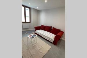 un soggiorno con divano rosso e tavolo di Appartement très spacieux & Coupery a Guillaumes