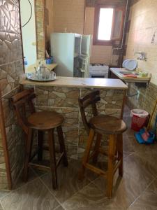 a kitchen with two stools and a counter with a refrigerator at Ashour Tower Ramy Abdulla For Families only in Marsa Matruh +50 photos
