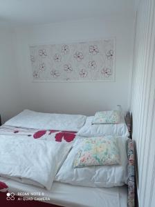 a bed with two pillows on it in a bedroom at Sárgapart Holiday Home in Poroszló