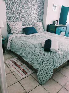 um quarto com uma cama com um edredão verde e branco em Blanc de Tardy em Saint-Étienne