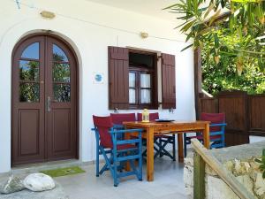 a patio with a wooden table and chairs at Fetsis Apartments in Agios Nikitas