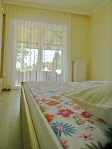 ein Schlafzimmer mit einem Bett mit einer Blumendecke in der Unterkunft Sorella in Kostol