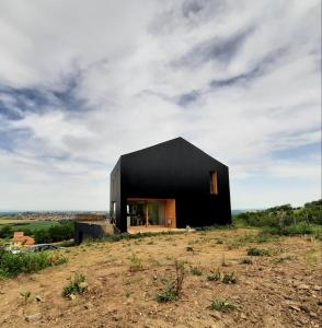 a black house on top of a hill at élégante villa neuve d'architecte in Dallet