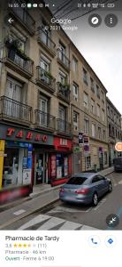 ein Auto steht vor einem Gebäude in der Unterkunft Blanc de Tardy in Saint-Étienne