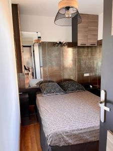 a small bedroom with a bed and a desk at Juan les Pins Joli T2 parking inclus! in Antibes