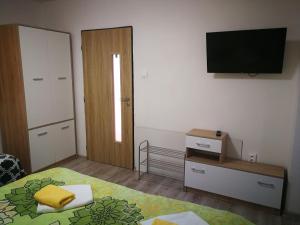 a bedroom with a bed and a television on the wall at Apartmány pri Zvonici in Oravský Podzámok