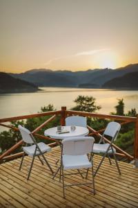 a table and chairs on a deck with a view of the water at Zoranovi konaci in Jevtići