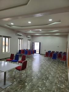 a room with chairs and tables and blue chairs at Camas Hotel & Suite Asero Abeokuta in Abeokuta