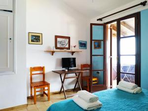 a bedroom with a desk and a bed with pillows at Fetsis Apartments in Agios Nikitas