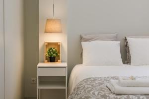a bedroom with a bed and a night stand with a plant at Oportments - Oliveiras in Porto