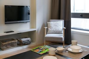波多的住宿－Oportments - Oliveiras，客厅配有桌子、椅子和电视