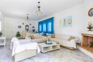 sala de estar con muebles blancos y chimenea en Casa Mia - 5 min from Stafilos beach, en Skopelos Town