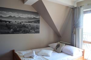 Pokoje Goscinne Pieninska Parzenica في Mizerna: غرفة نوم بسرير مع صورة على الحائط