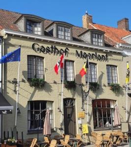 een restaurant met vlaggen voor een gebouw bij Gasthof Maerlant in Damme