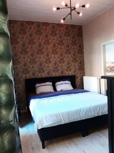 a bedroom with a bed and a wall with avertisement at B&B Janine in Ostend