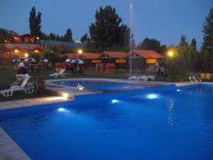 a large blue swimming pool at night at Posada Cacheuta in Las Compuertas