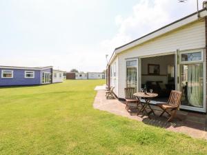 a patio with chairs and a table next to a house at Chalet 150 in Great Yarmouth