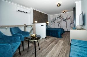 sala de estar con sillas azules y sofá en ApartPark ALBUS 401 SEA VIEW above the trees, en Świnoujście