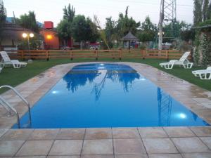 a pool with blue water in a yard at Posada Cacheuta in Las Compuertas