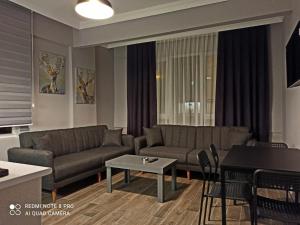 een woonkamer met banken en een tafel bij Merve Apart Hotel in Alanya