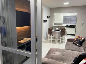 a living room with a couch and a dining room at LINDO APARTAMENTO 1822 in Balneário Camboriú +10 photos