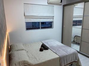 a bedroom with a bed with a pair of shoes on it at LINDO APARTAMENTO 1822 in Balneário Camboriú