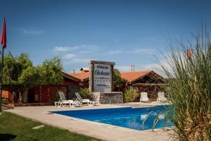 a swimming pool in front of a house with a sign at Posada Cacheuta in Las Compuertas