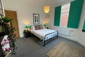 a bedroom with a bed and a green wall at BOUTIQUE CITY CENTRE APARTMENT WITH PARKING in Chester