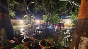 a patio with a bunch of plants and tables and chairs at Hostel Lifespace- Garden Bungalow with Pods, CoWork & Cafe in Pune