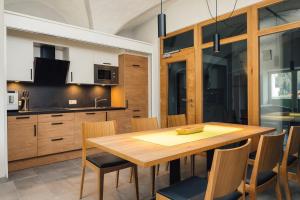 een keuken en eetkamer met een houten tafel en stoelen bij Nowders Apartments und Zimmer in Nauders