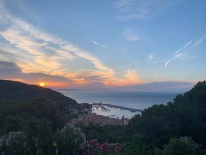 a view of a city and the ocean at sunset at Blue Living - Alta Marina in Marciana Marina